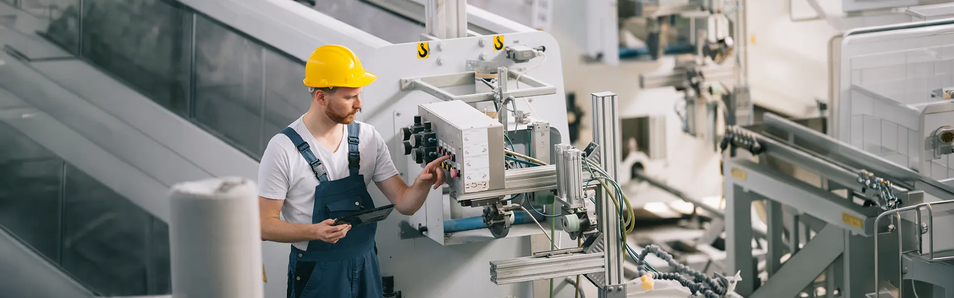 Technicien avec tablette supervisant une ligne de production : industrie 4.0 et assurance cyber pour PME