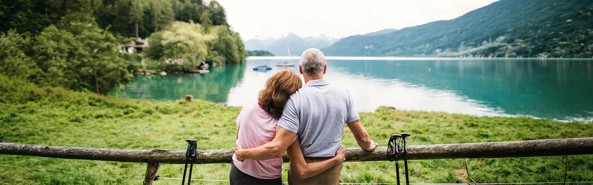 Couple de retraités frontaliers regardant un lac suisse avec vue sur les montagnes